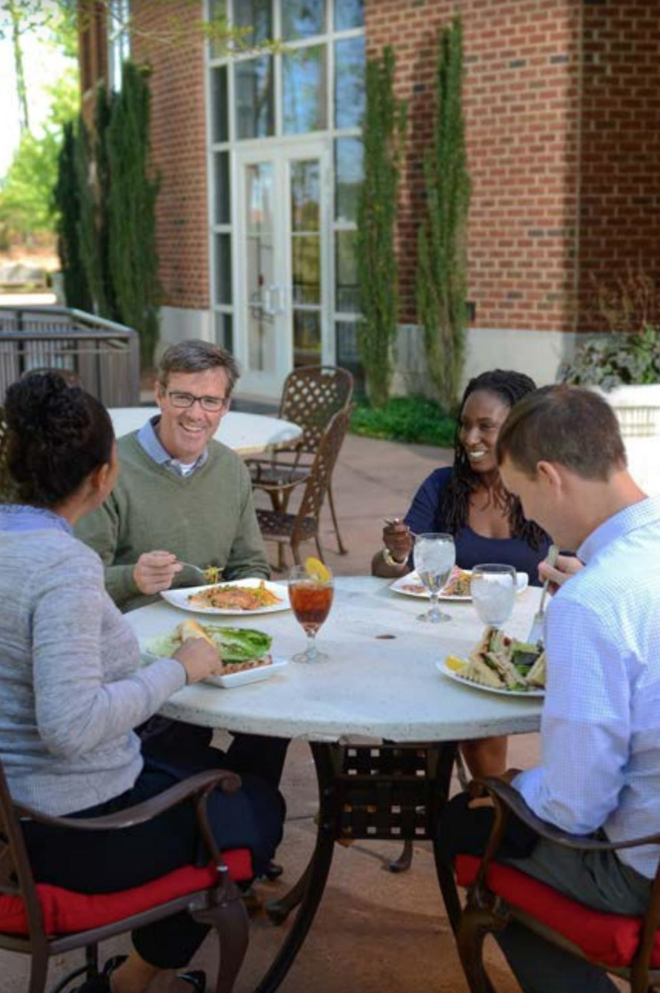 People gathered around a table eating.