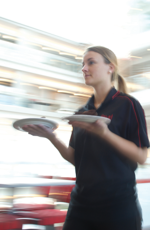 A caterer carries plates of food at a Rave-catered event.