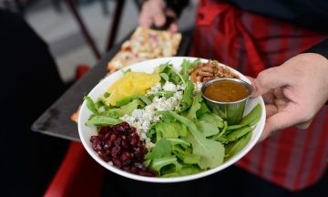 Photo of a person's hand holding a plate of food