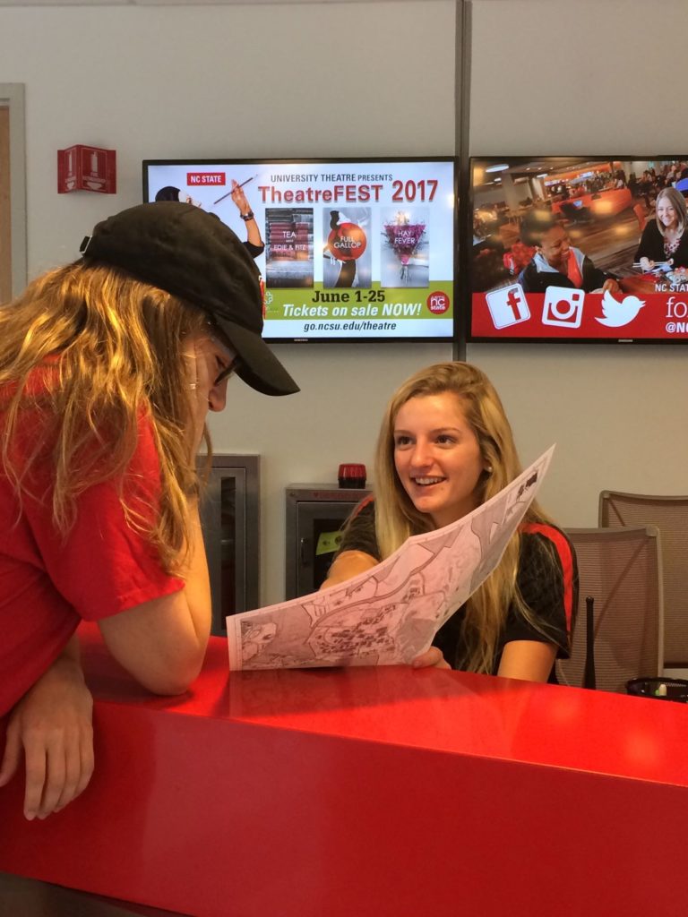 Student employee assisting a customer at the information desk